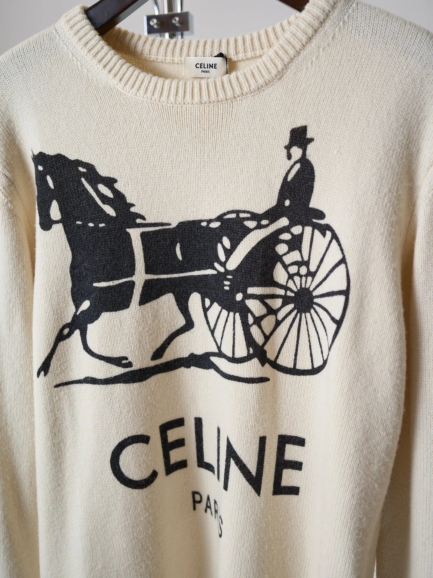 [Real object hanging] CELINE/Celine carriage print round neck knitted sweater [In Stock] S M L XL Fabric selection: Made of 62% wool + 23% nylon + 15% anti-pilling acrylic blended yarn, precision woven on an imported 7-needle knitting machine. The 7-needle medium-thick knitted structure makes the fabric fluffy and thick, with excellent temperature-locking ability; wool gives the fabric a soft, waxy and skin-friendly texture, while nylon strengthens the toughness and prevents it from loosening and deforming. It is paired with anti-pilling acrylic to give it both comfort and durability, and a solid texture. Printing process: The Classic carriage pattern and letters on the chest adopt a reactive printing process. The dye penetrates into the knitted fiber and is not offset printed on the surface. The pattern lines are clear and neat, and the touch is natural without a hard glue layer. It is not easy to crack or peel after repeated wear and washing, and the original soft texture of the knitted fabric is completely retained. Details: The round neck, cuffs and hem are made of high-density wide rib weaving, which has long-lasting elasticity and will not loosen easily after long-term wear; the back shoulders are made of hollow keyhole technology, and the entire line is evenly routed.